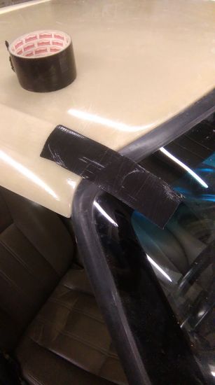 Tape the targa panel to the windscreen to prevent movement